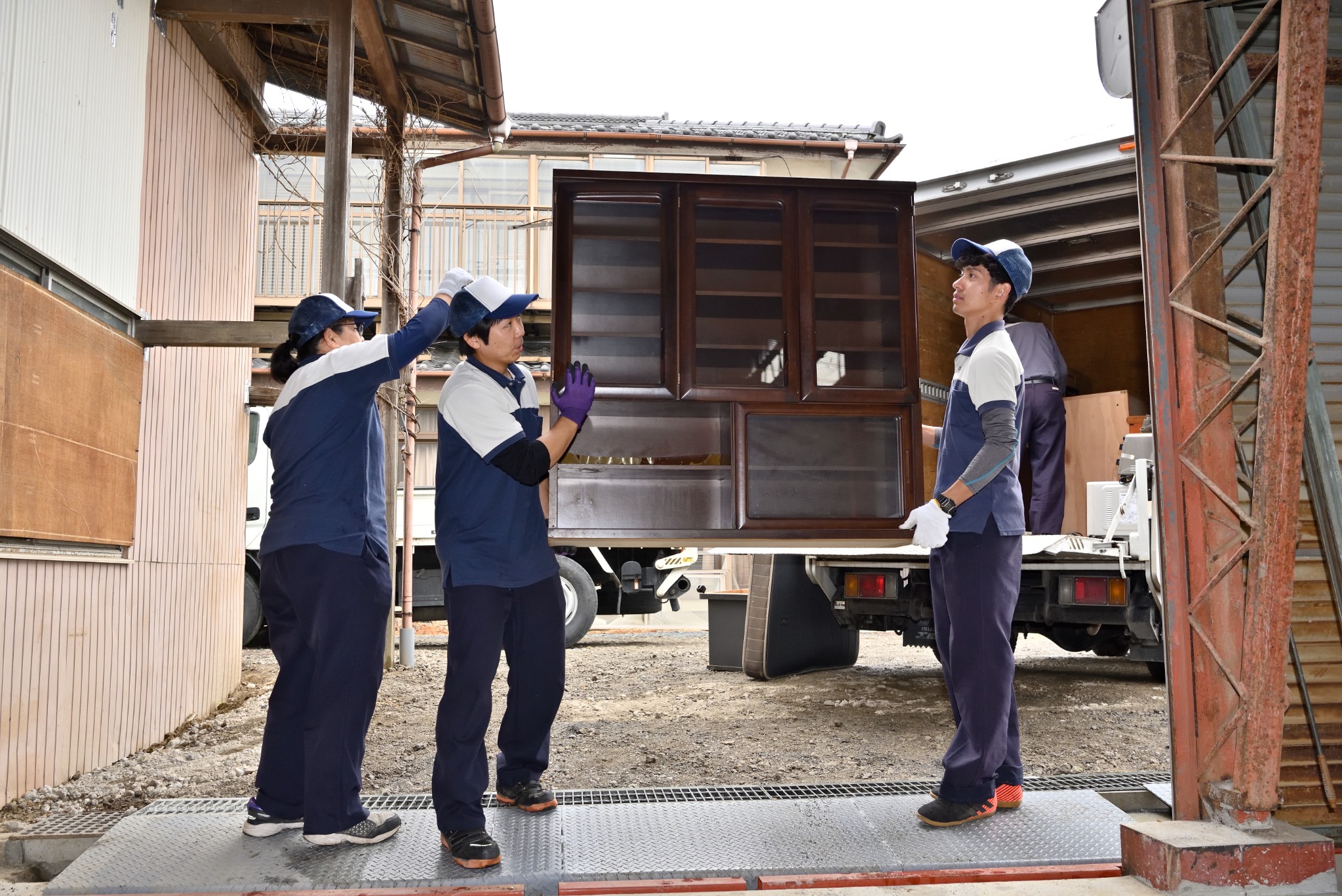 複数のスタッフで大型家具をトラックへ搬出する様子